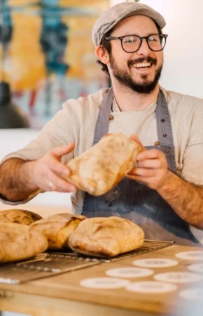 Seminarleiter des Brotbackkurses praesentiert fertiges Ciabatta